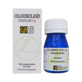 La imagen muestra una caja y un frasco de Oxandroland - LANDERLAN de Get Fit México. La caja blanca con texto negro tiene un logotipo y dice: Oxandrolona 5 mg, 100 comprimidos, Via Oral, Industria Paraguaya. El frasco azul tiene una tapa blanca con etiquetas a juego.
